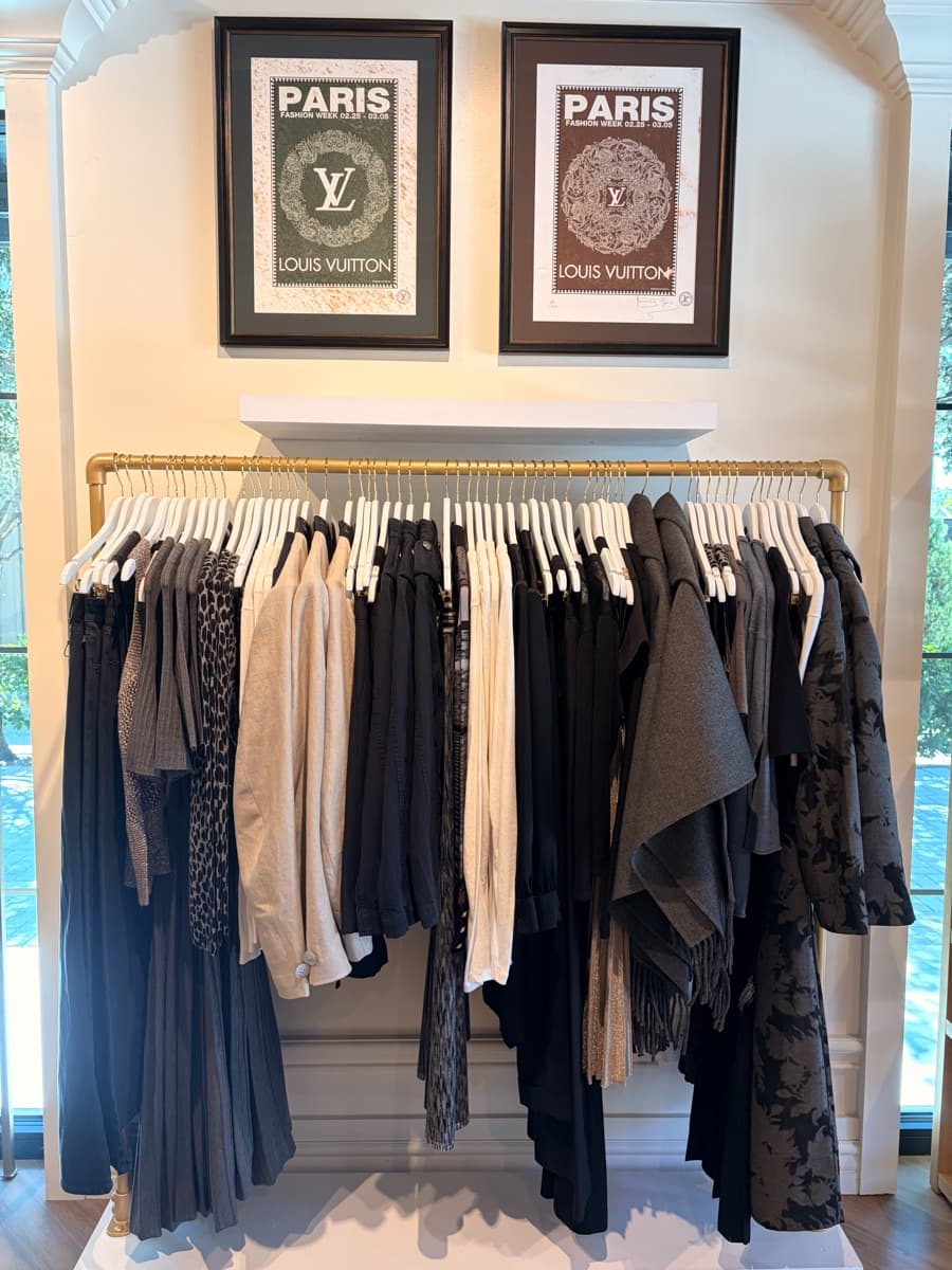 Clothing rack beneath framed posters